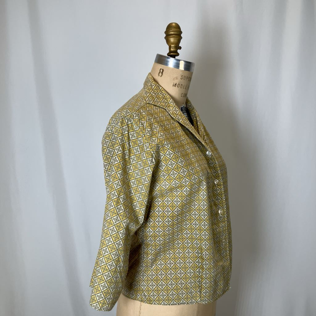 Green patterned jacket on a mannequin against a white background