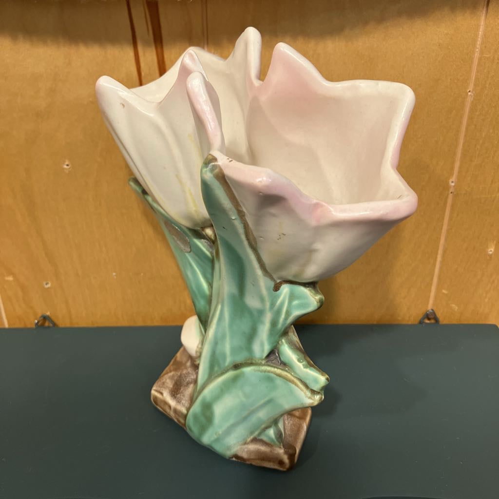 Ceramic tulip flower vase on a dark surface with a wooden background