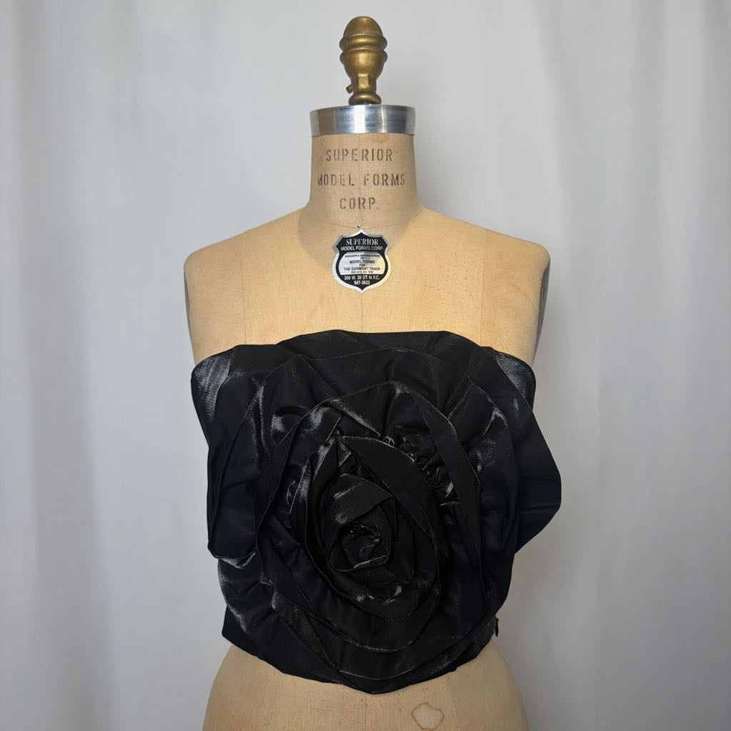 Photo of a black corset top with flower design on a mannequin against a white background