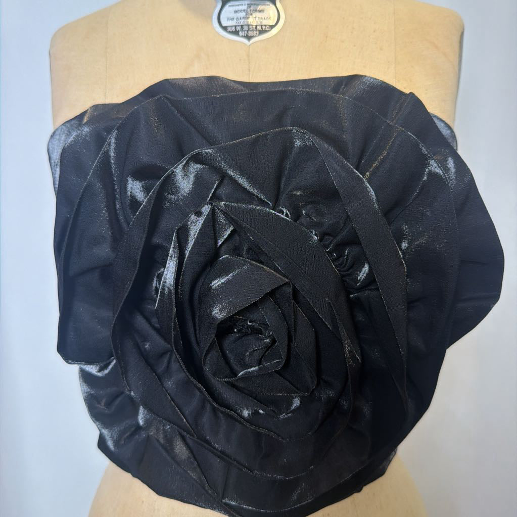 Photo of a black corset top with flower design on a mannequin against a white background