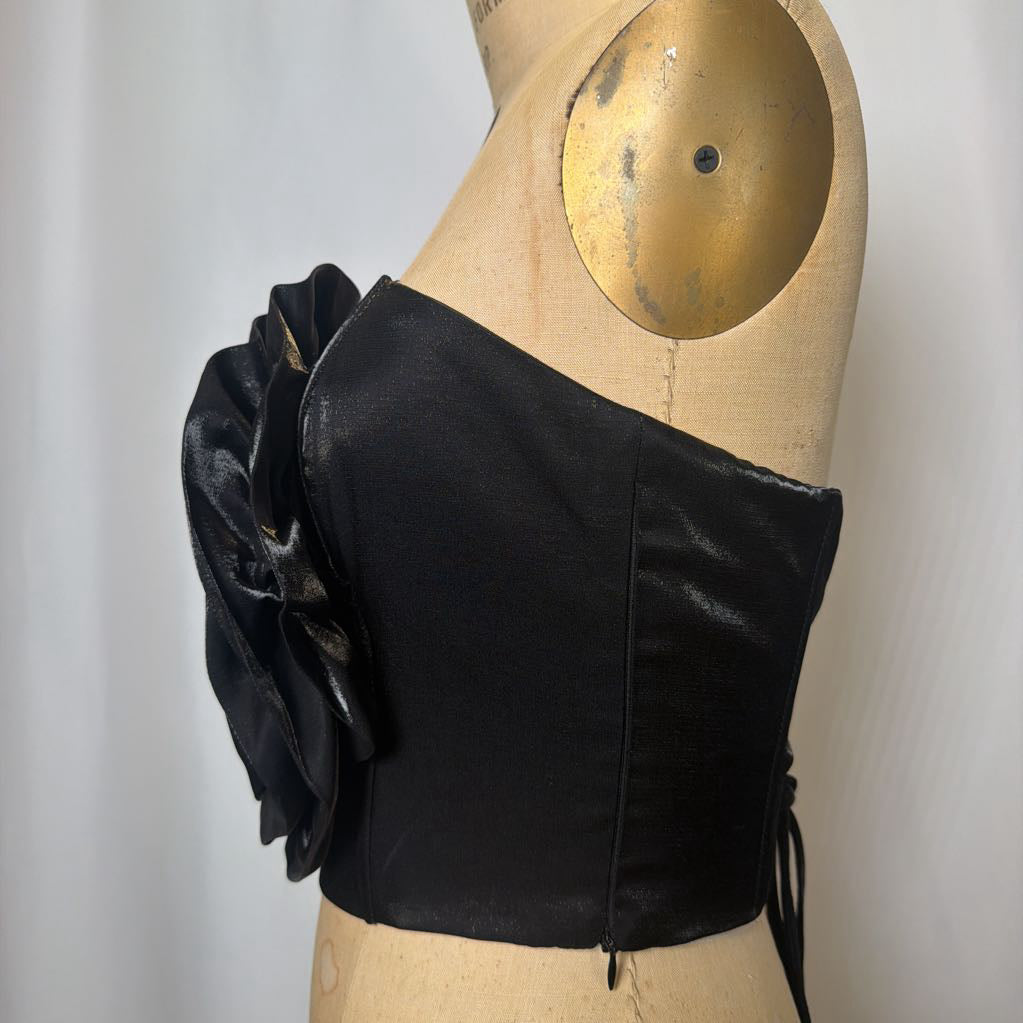 Photo of a black corset top with flower design on a mannequin against a white background