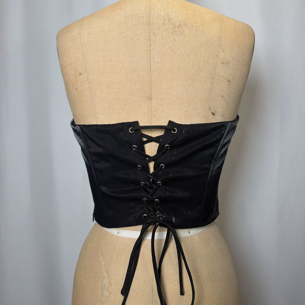 Photo of a black corset top with flower design on a mannequin against a white background