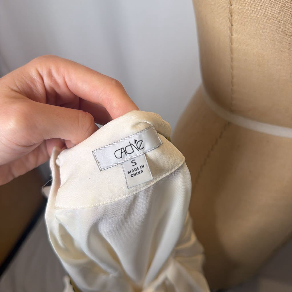 Close-up of a garment label on a white shirt with a beige background