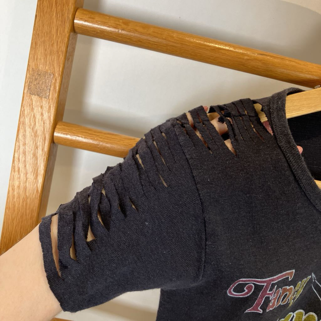 Black sleeveless top with cut-out shoulders on a wooden hanger