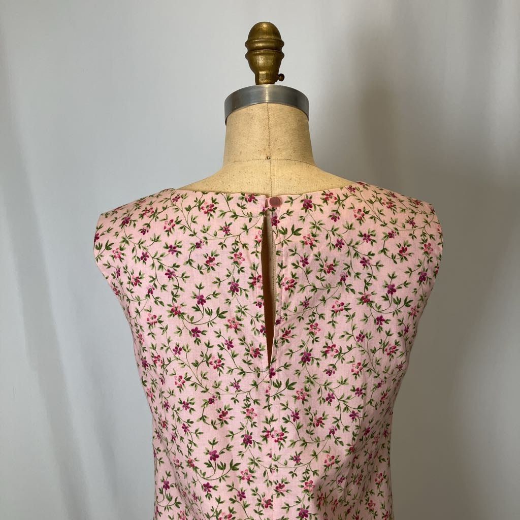 Mannequin wearing a pink floral dress with a plain background