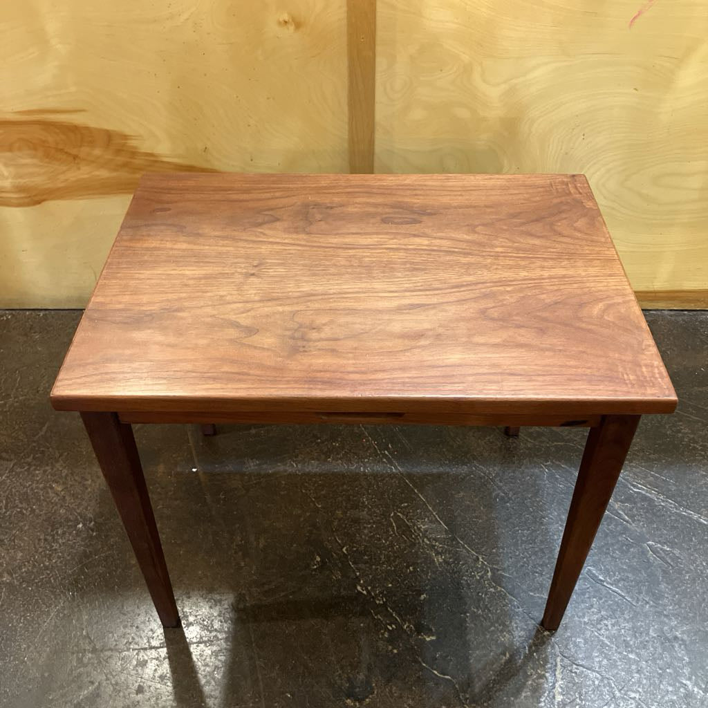 Wooden table with a brown finish on a reflective floor.