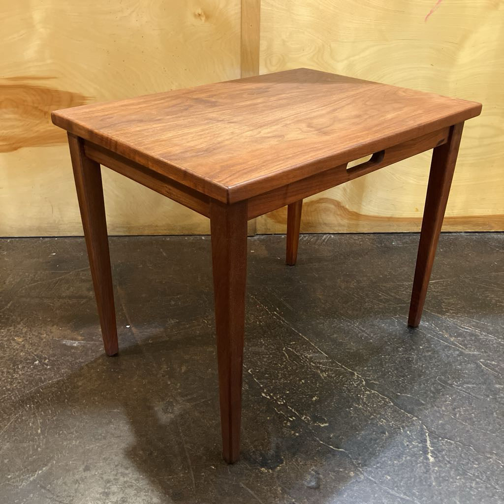 Wooden table on a dark stone floor with a wooden wall background