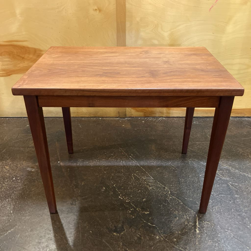 Wooden table on a dark floor with a wooden wall background