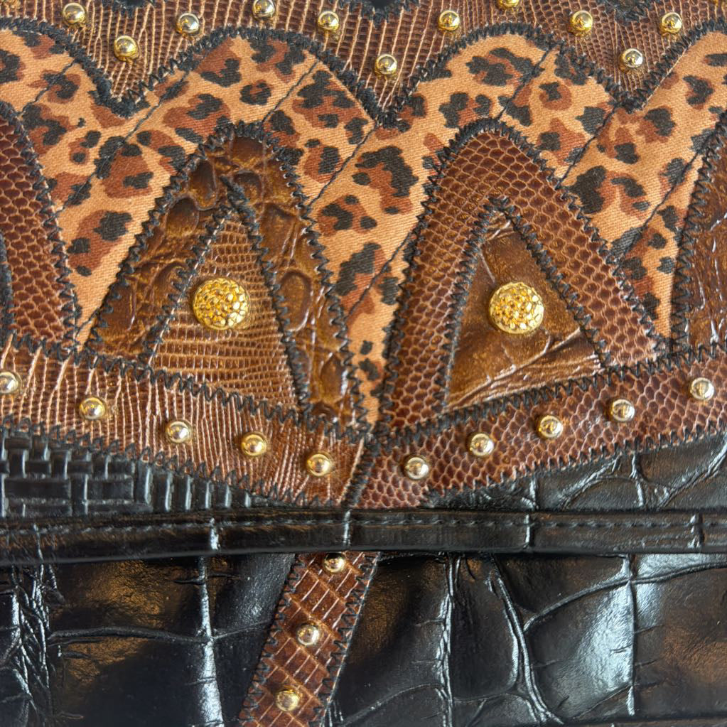 Close-up of a handbag with leopard print and gold studs