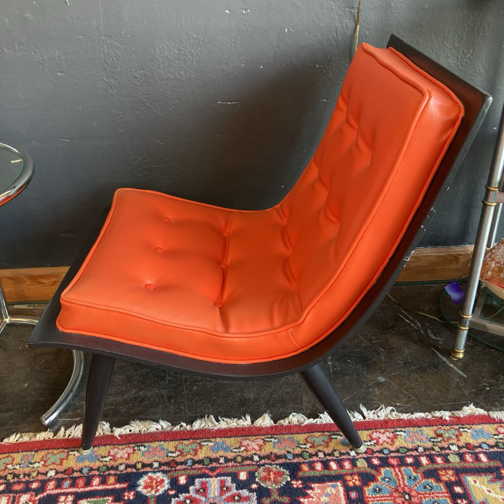 Side of the Orange mcm tufted vinyl scoop chair with walnut wood frame that has been painted black