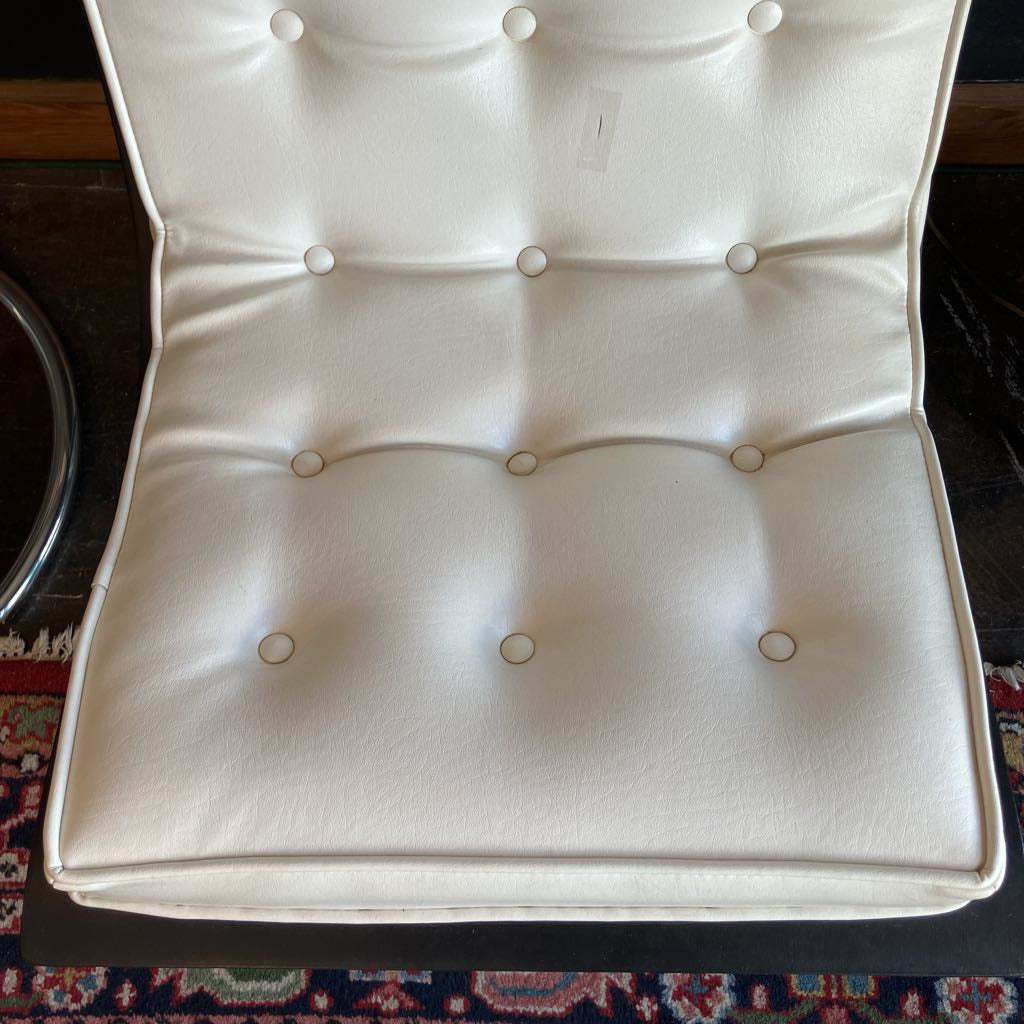 Close up of the seat area on white mcm tufted vinyl scoop chair with walnut wood frame that has been painted black