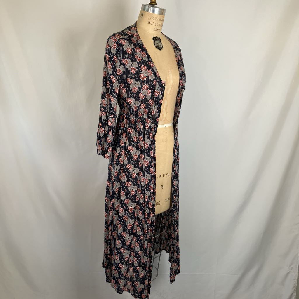 A long-sleeve floral cardigan or robe displayed on a dress form mannequin against a white fabric backdrop. The garment has a dark navy or black base with a pink and light blue floral pattern.
