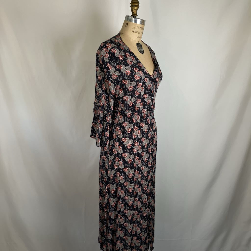 A long-sleeve floral maxi dress displayed on a vintage dress form mannequin against a white fabric backdrop. The dress features a dark navy or black base with a pink and light blue floral pattern.