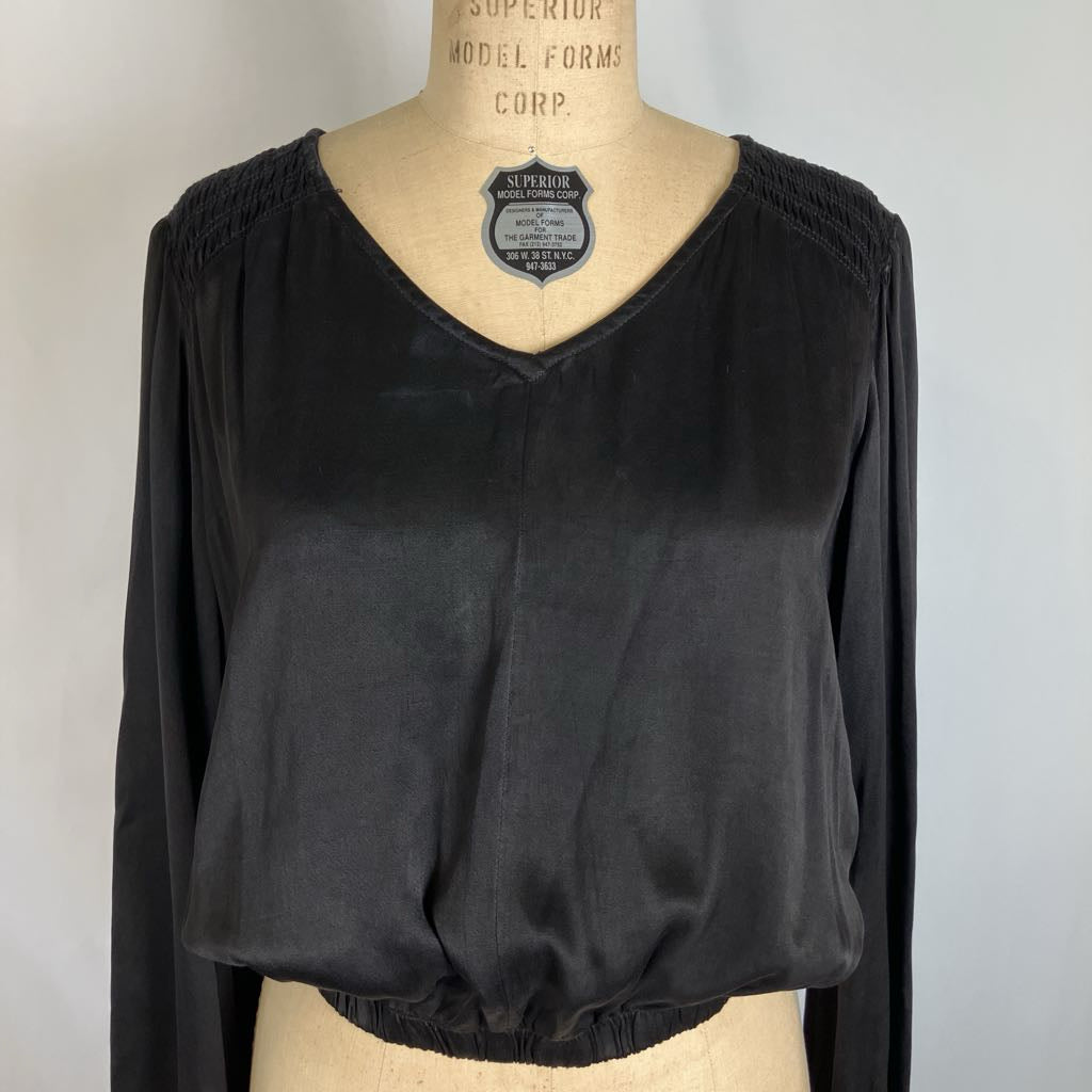 A black long-sleeve V-neck blouse displayed on a beige dress form mannequin against a light gray background.