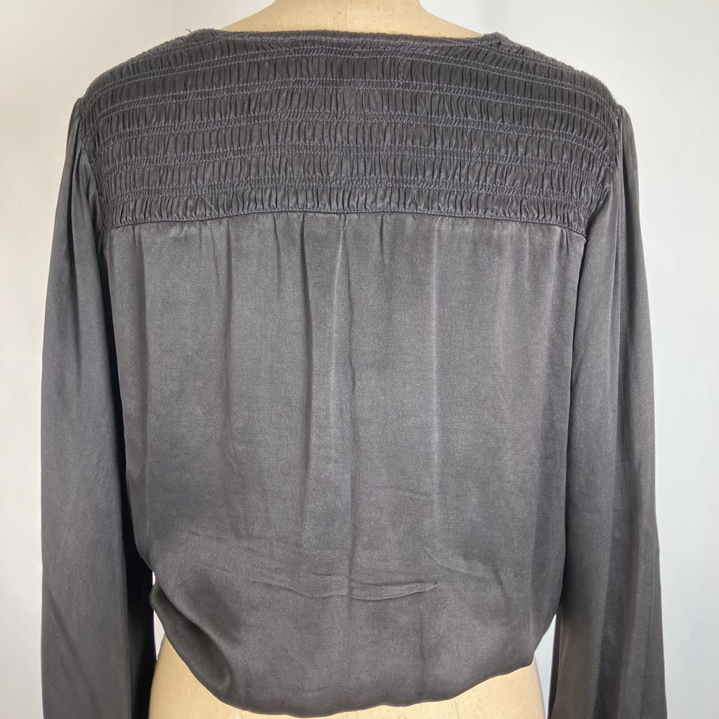 A dark gray long-sleeve blouse with a smocked bodice, displayed on a mannequin against a plain light background.