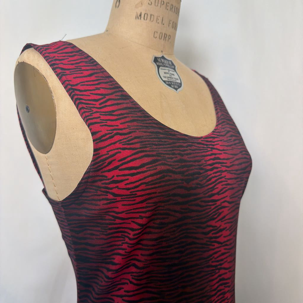 A sleeveless scoop-neck top with a red and black zebra-like stripe pattern, displayed on a beige dress form mannequin against a plain white background.