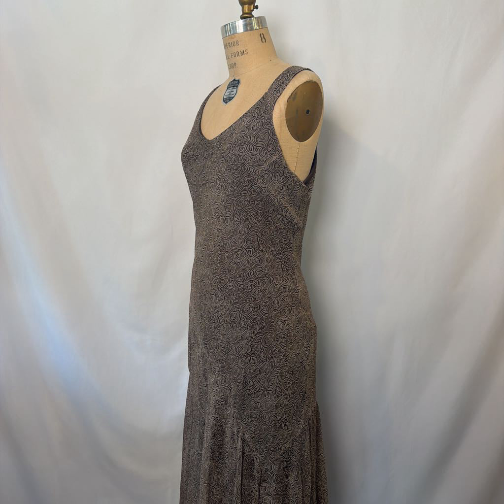 A sleeveless, scoop-neck maxi dress in a heathered brown and gray knit fabric, displayed on a vintage wooden dress form against a white fabric backdrop.