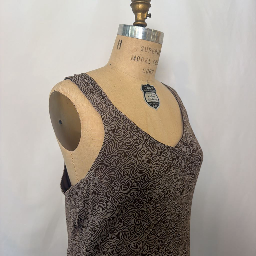 A sleeveless scoop-neck top with a brown and black swirling abstract pattern, displayed on a vintage fabric dress form mannequin against a white background.