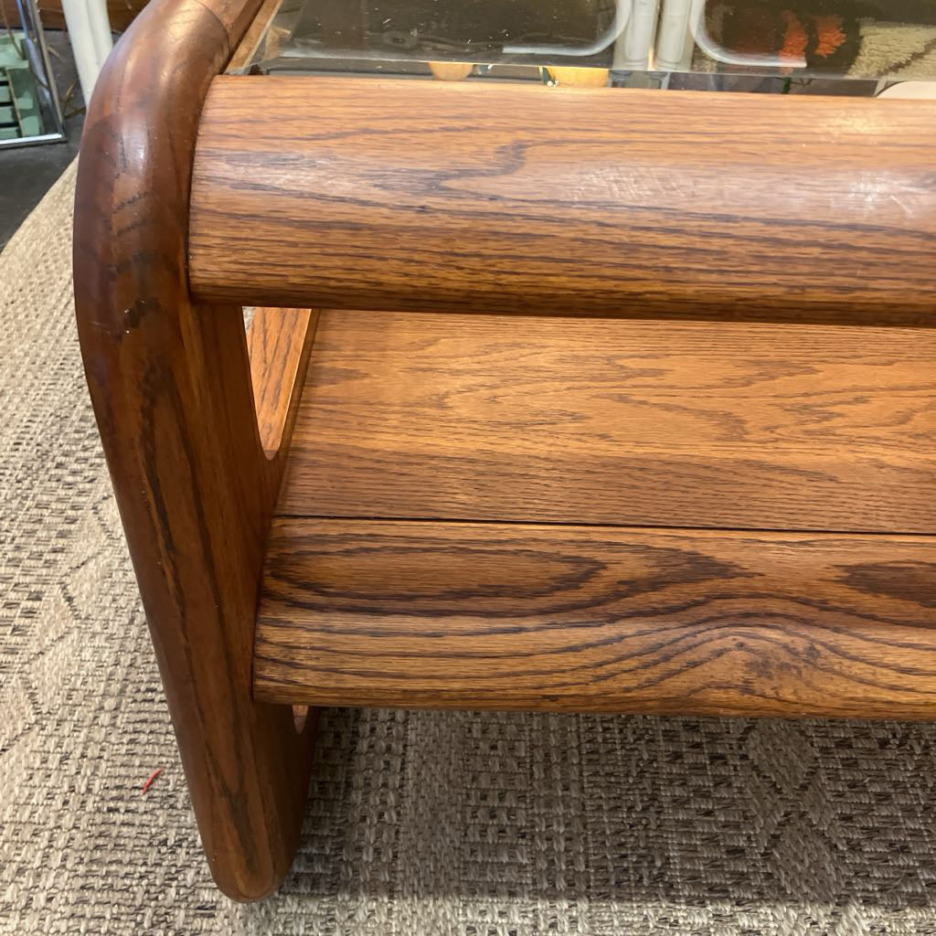 Close-up of a wooden furniture piece showing the rich grain of medium-to-dark brown wood, with a curved leg and a shelf or divider.