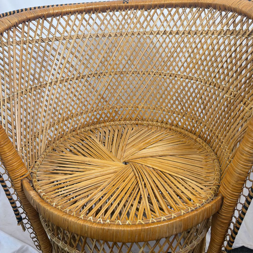 Close-up of a woven rattan chair back and seat, showing natural tan and light brown woven material with a circular seat and curved backrest.