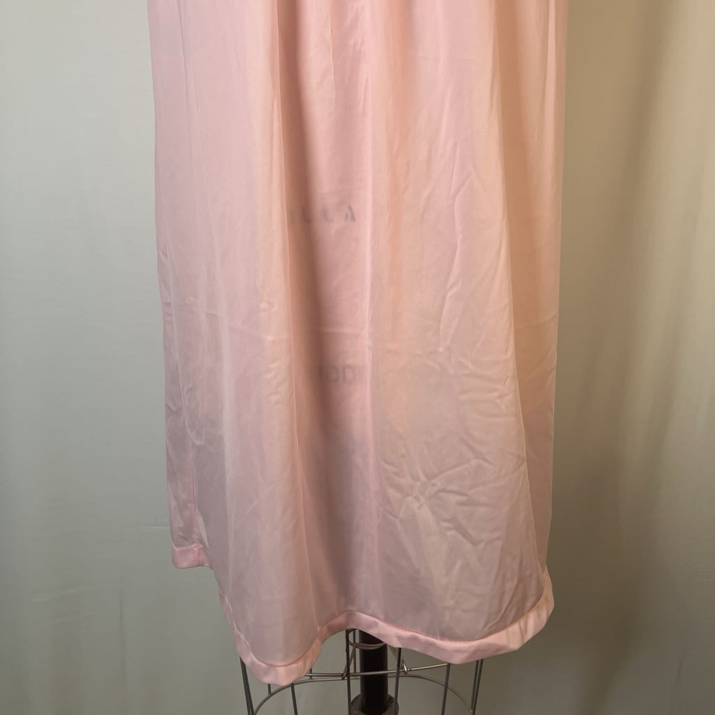 A light pink sheer fabric curtain or drape hanging from a metal stand against a plain light background.