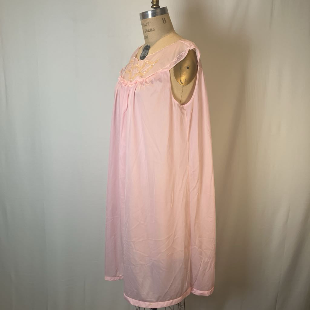 A light pink long-sleeve nightgown displayed on a dress form mannequin against a neutral light gray fabric backdrop.