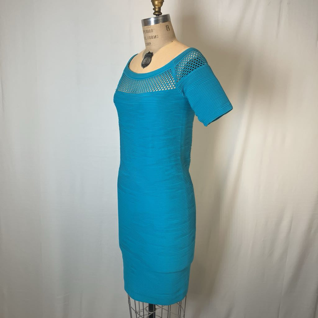 A bright turquoise blue short-sleeve knit dress displayed on a dress form mannequin against a white fabric backdrop.