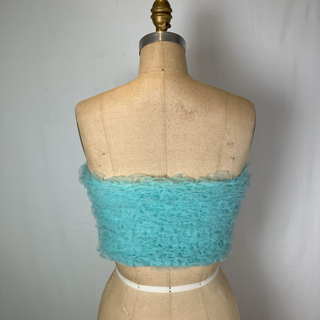 A turquoise fuzzy strapless tube top displayed on a vintage tan dress form mannequin against a light gray fabric backdrop.
