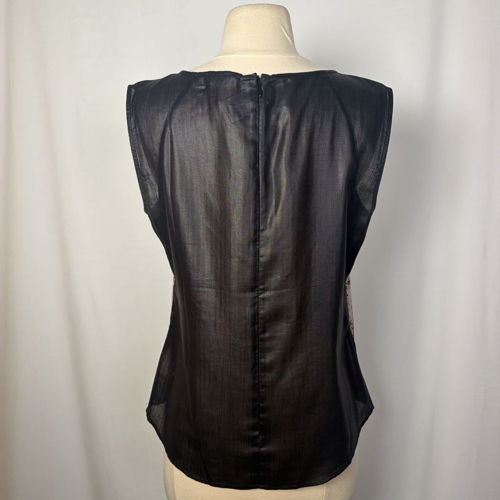 A black sleeveless top displayed on a cream mannequin torso against a white curtain background, showing the back view with a central seam and zipper.