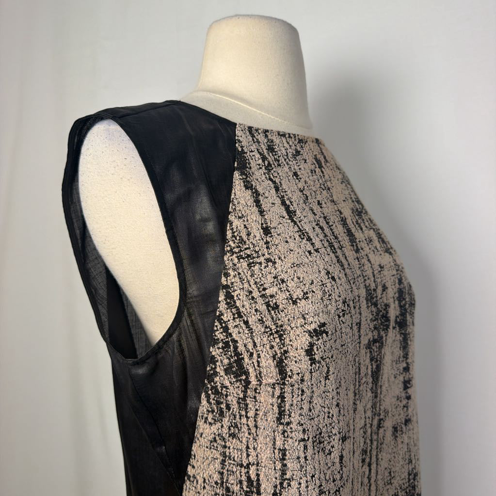 A sleeveless black and beige patterned dress displayed on a cream mannequin torso against a light gray background.