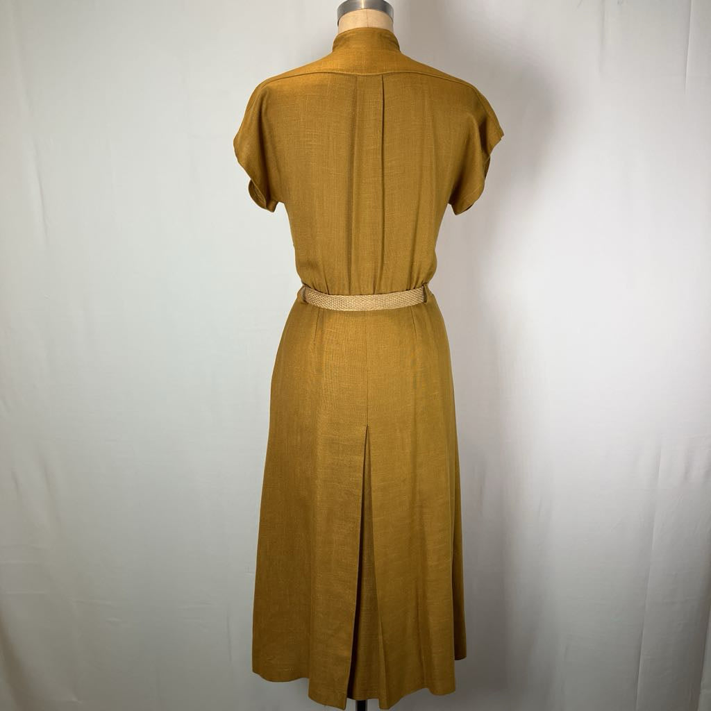 A mustard yellow linen dress shown from the back on a dress form mannequin, featuring short sleeves, a high collar, a back pleat, and a matching waist belt.