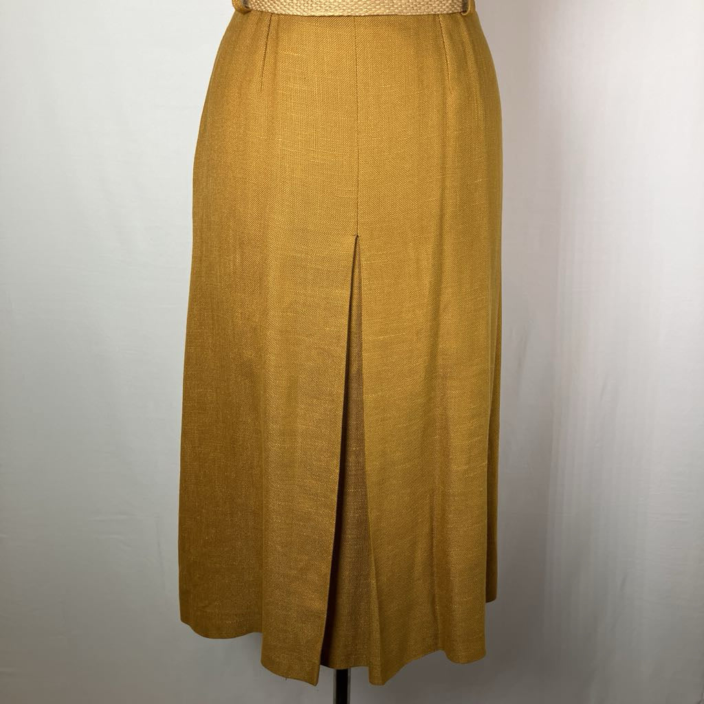 A mustard yellow linen midi skirt with a front slit, displayed on a mannequin against a light gray background.