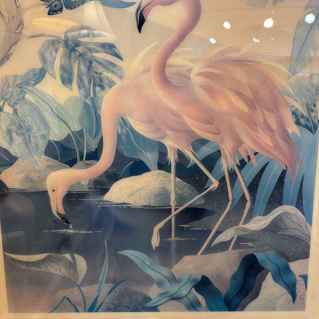 A stylized artwork of a pink flamingo standing in shallow blue water among large tropical leaves, with a soft cream background and subtle light reflections near the top.