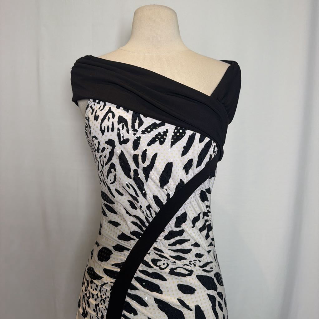 A black and white patterned off-the-shoulder dress displayed on a beige mannequin torso against a light gray fabric backdrop.