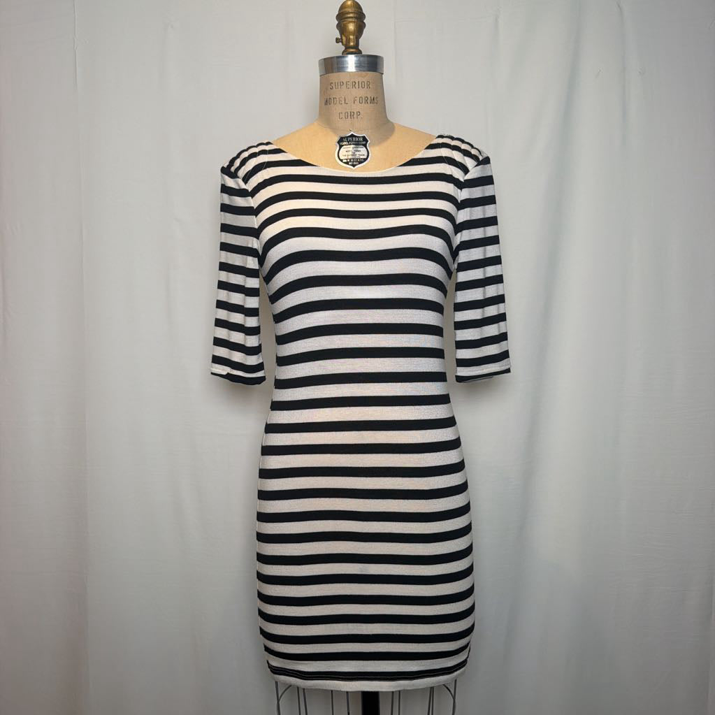 A black and white horizontally striped knit dress displayed on a beige dress form mannequin against a white fabric backdrop.