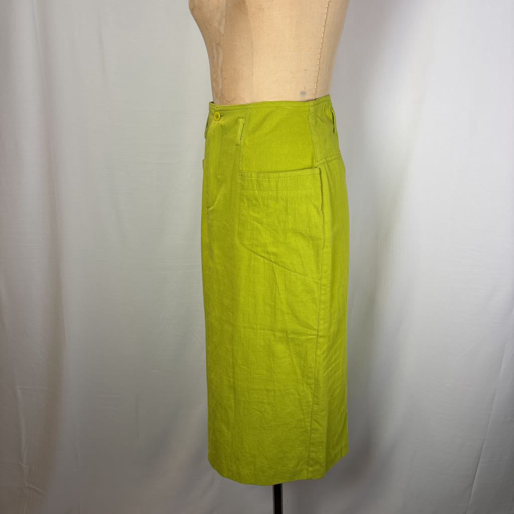 A bright lime green linen pencil skirt displayed on a beige dress form mannequin against a white fabric backdrop.