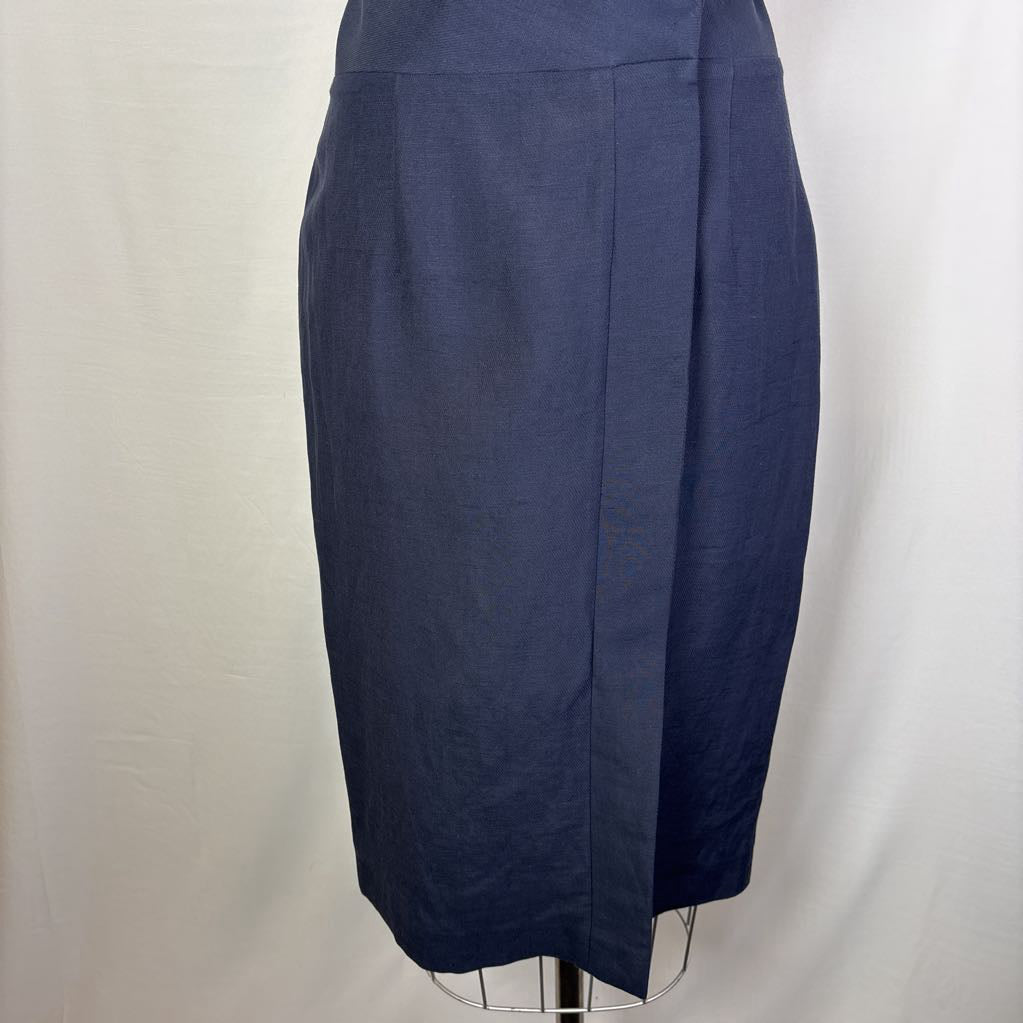 A navy blue knee-length skirt displayed on a wire dress form against a white fabric backdrop.
