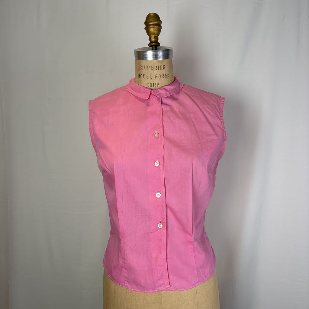 A sleeveless pink button-front blouse displayed on a tan dress form mannequin against a light gray fabric backdrop.
