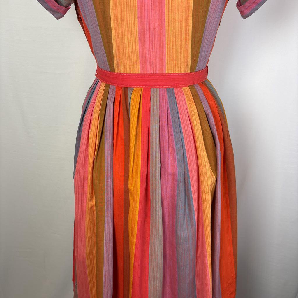 A close-up of a vintage striped dress on a mannequin, featuring vertical stripes in orange, pink, red, yellow, and brown, with a matching red waist belt.