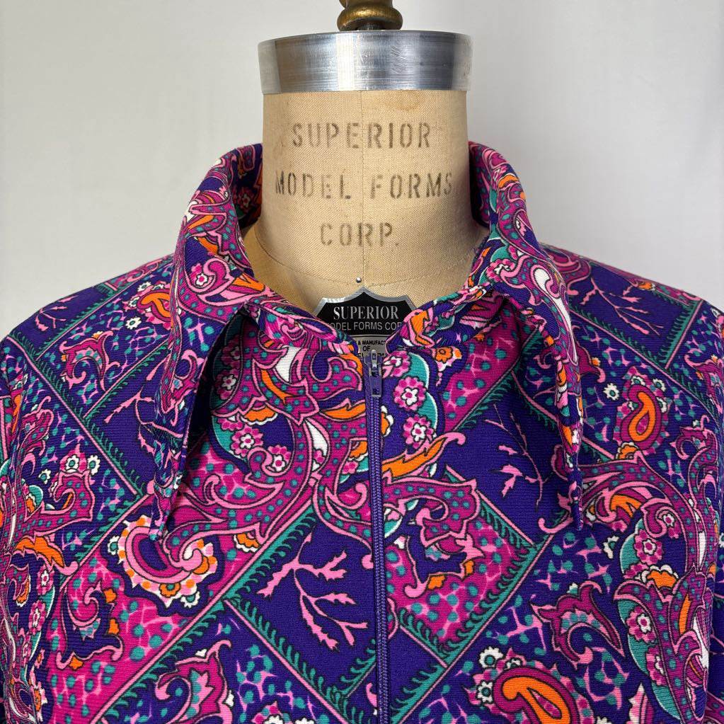 A vibrant purple and pink paisley patterned button-up shirt displayed on a vintage Superior Model Forms Corp. dress form against a plain light background.