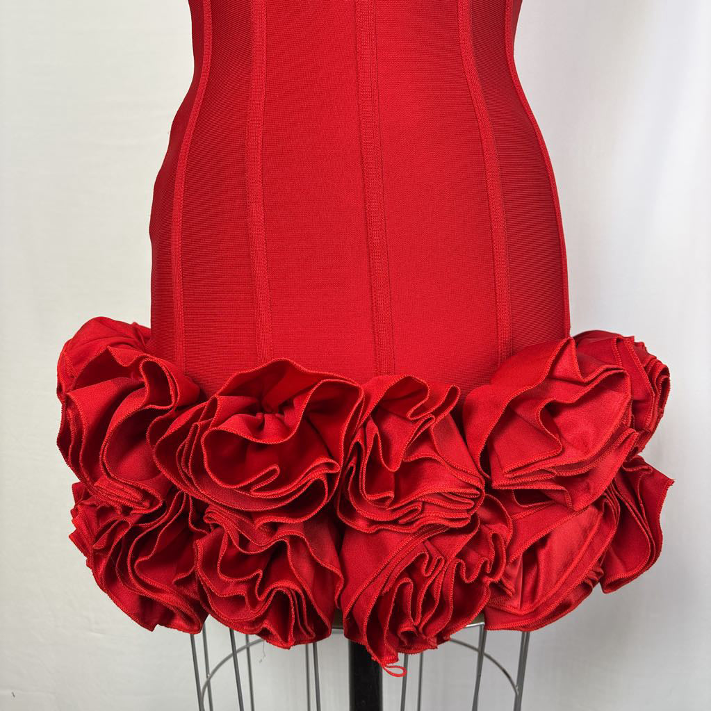 A bright red corset-style dress form or torso mannequin with a large ruffled floral skirt detail, photographed against a plain light background.