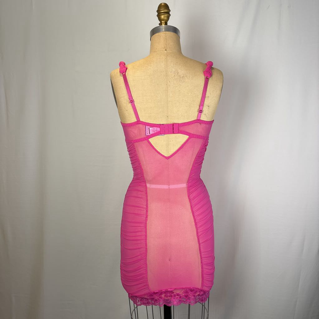 A bright pink sheer mesh chemise-style lingerie dress displayed on a tan dress form mannequin against a white fabric backdrop.