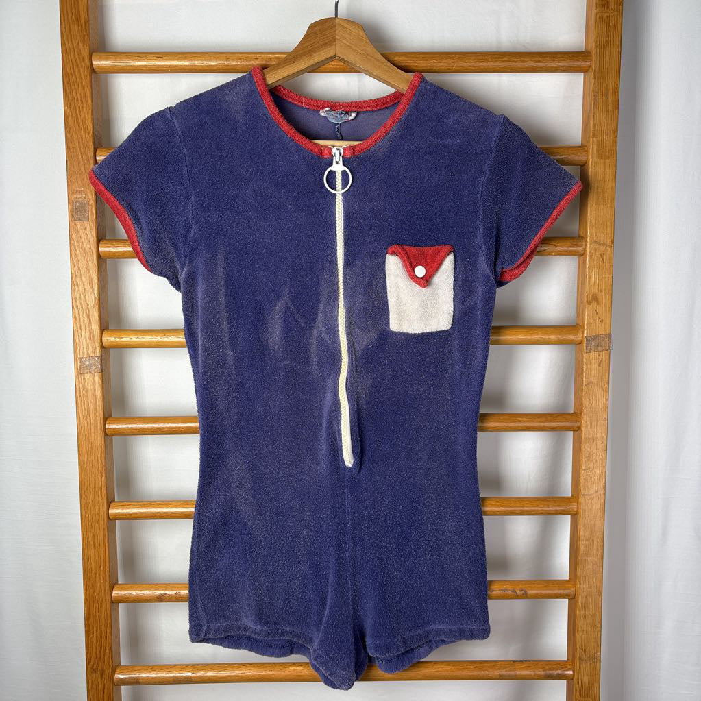 Small vintage style navy romper on a wooden rack.