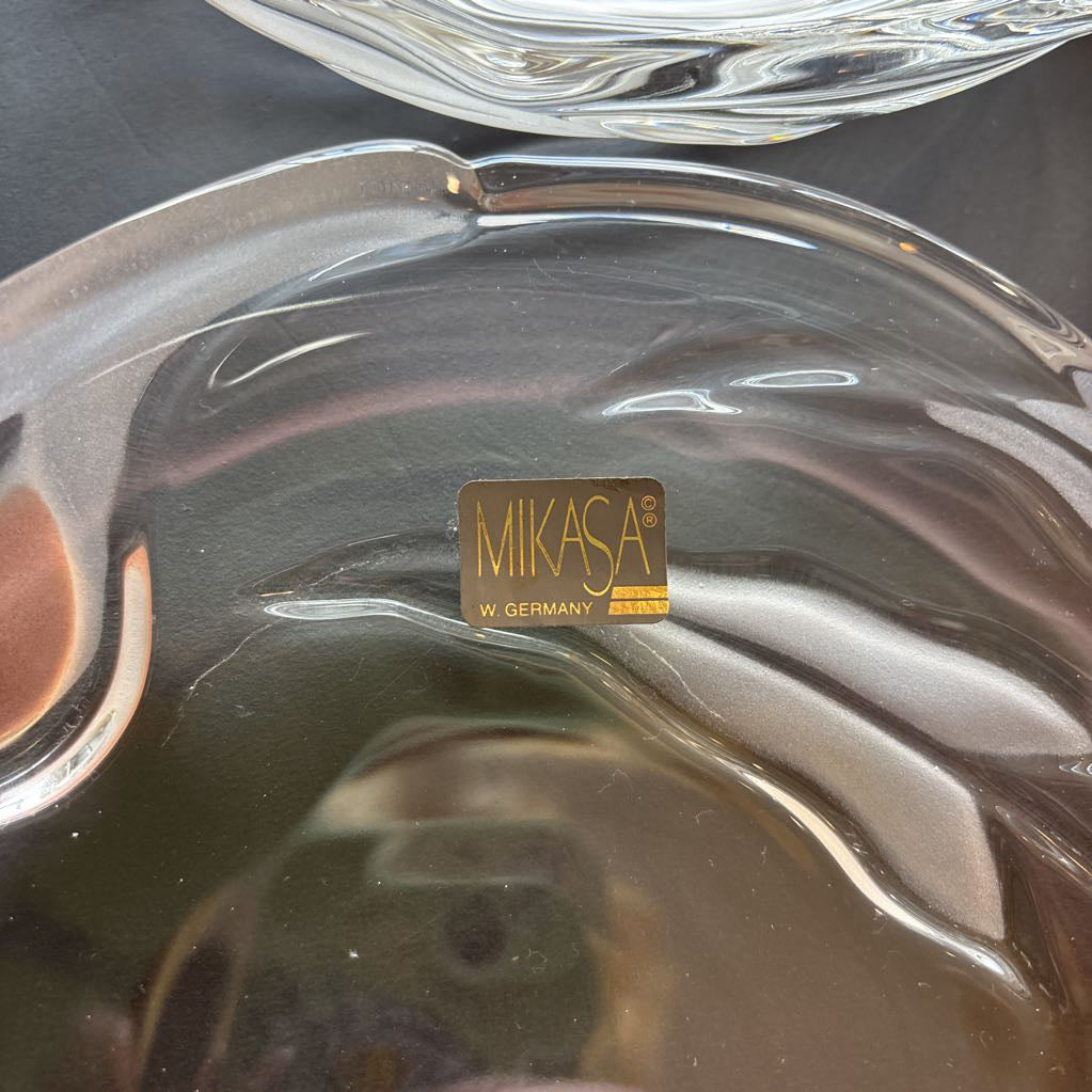 A glass plate with embossed frosted pink calla lilies and a sticker that reads 'MIKASA W GERMANY' sitting on a black table.
