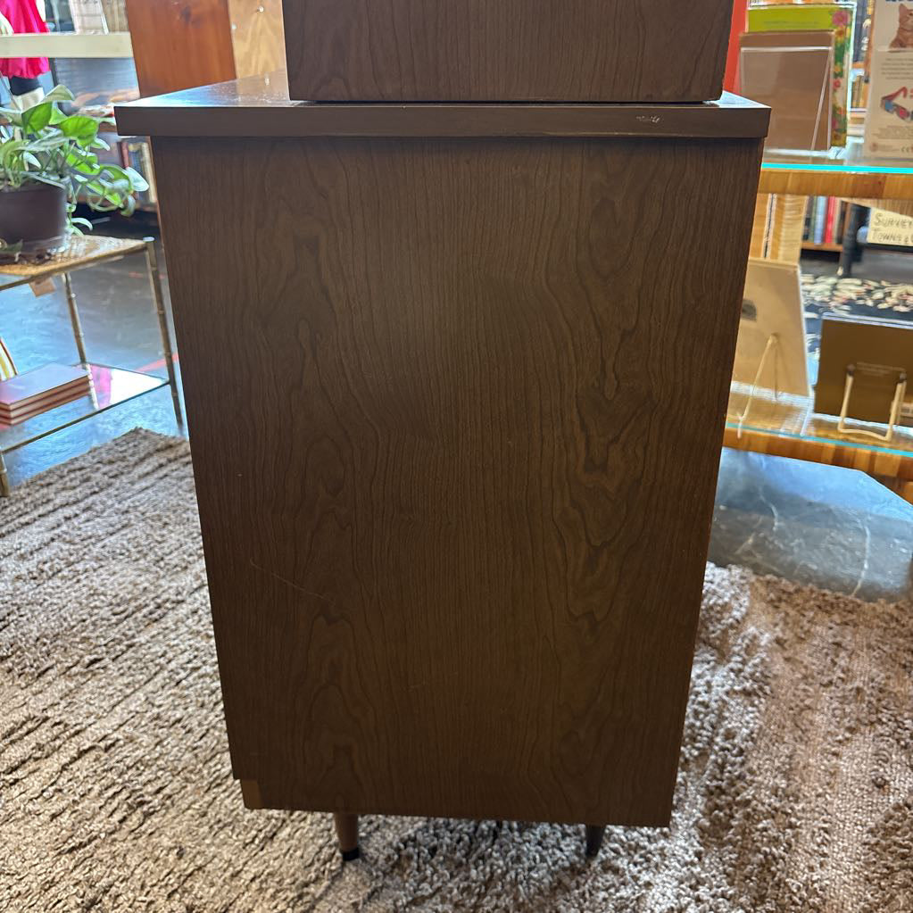 The side of a large wooden hutch in a store setting.