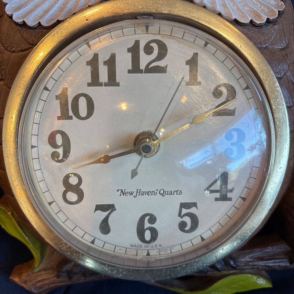 A vintage clock on a blue cushion.