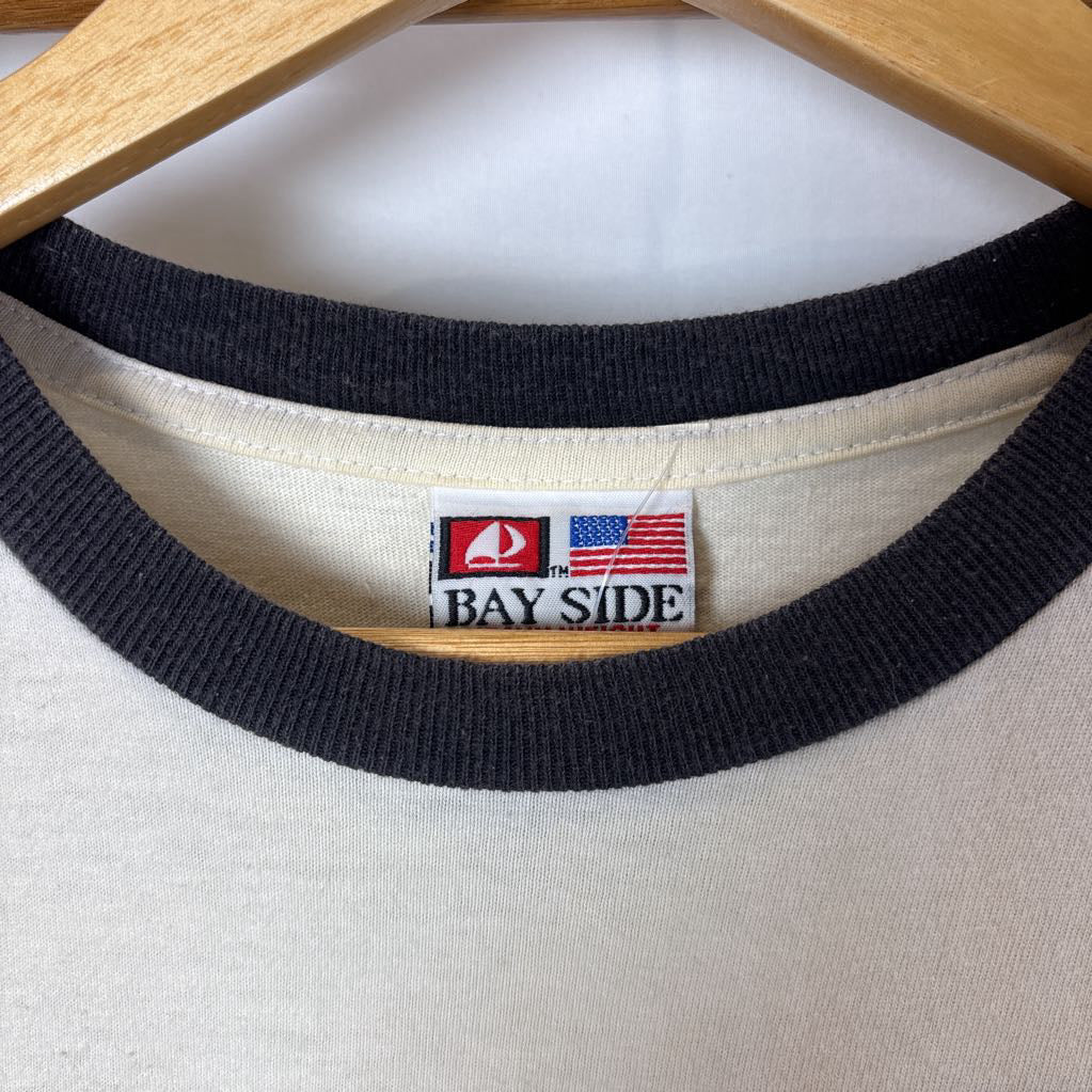 A white vintage style short sleeve t-shirt on a wooden rack against a white background.