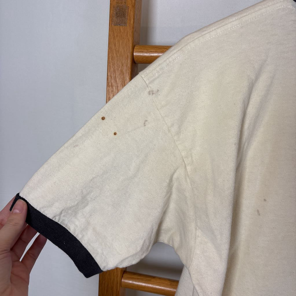 A white vintage style short sleeve t-shirt on a wooden rack against a white background.