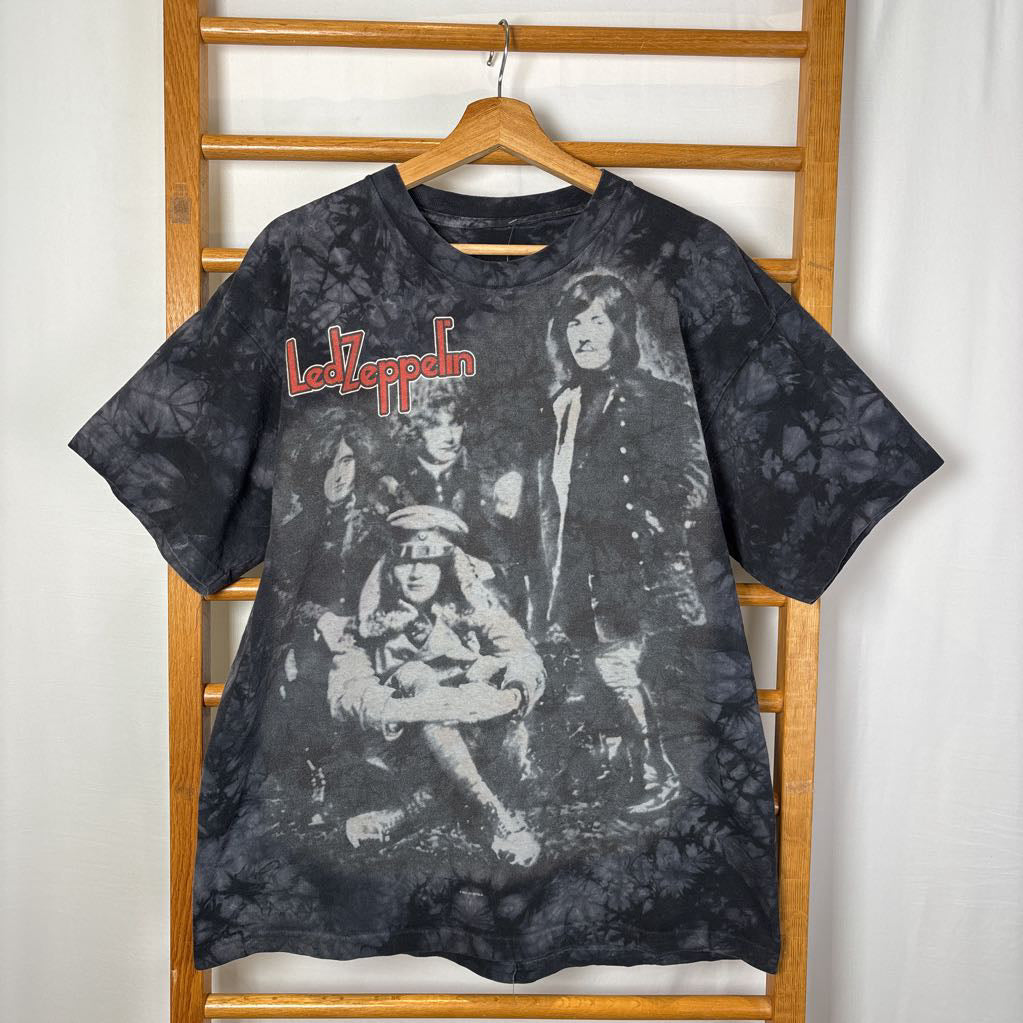 A dark gray tie-dye short sleeve t-shirt with an image of Led Zeppelin on it. The tee hangs on a wooden rack against a white background.