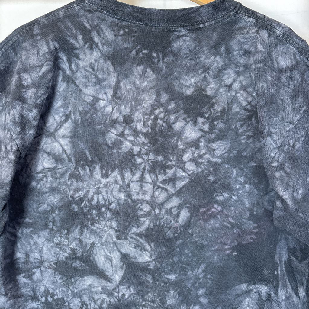 A dark gray tie-dye short sleeve t-shirt on a wooden rack against a white background.